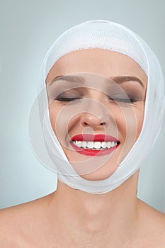 Beauty and Fashion. Woman after plastic surgery with bandaged face.