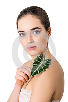 Beauty female portrait. Beautiful young woman holding green leaf over white background. Healthcare