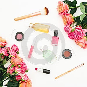 Beauty feminine composition with roses flowers and makeup cosmetics on white background. Flat lay, top view. Spring background