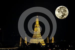 The beauty of the full Moon and Wat Arun at night with gold.