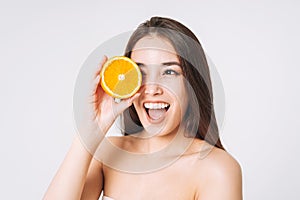 Beauty funny portrait of happy smiling asian woman with dark long hair with oranges in hands on white background isolated