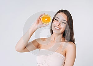 Beauty funny portrait of happy smiling asian woman with dark long hair with oranges in hands on white background isolated