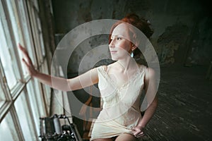 Beauty ginger woman at window, old house interior