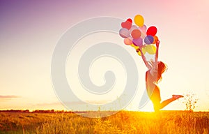 Beauty girl with colorful air balloons over sunset sky