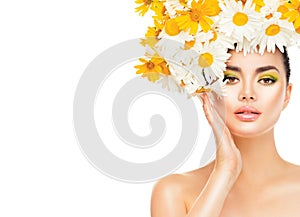 Beauty girl with daisy flowers hairstyle touching her skin