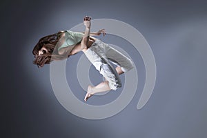 Beauty girl dance on grey background. person jumping, flying in the air