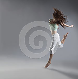 Beauty girl dance on grey background. person jumping, flying in the air