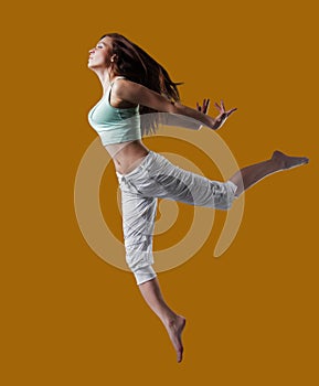 beauty girl dance on orange background. person jumping, flying in the air