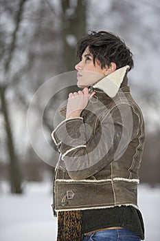 Beauty Girl in frosty winter Park. Outdoors. Flying Snowflakes.