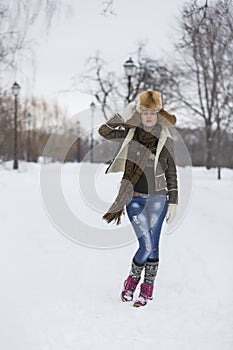Beauty Girl in frosty winter Park. Outdoors. Flying Snowflakes.