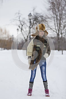 Beauty Girl in frosty winter Park. Outdoors. Flying Snowflakes.