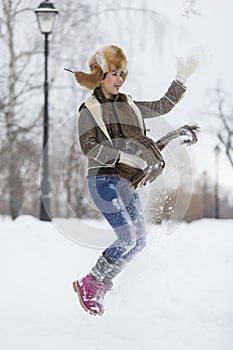 Beauty Girl in frosty winter Park. Outdoors. Flying Snowflakes.