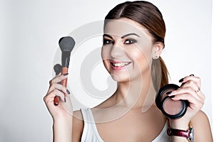 Beauty Girl make up artist with Makeup Brush. Bright Holiday Make-up for Brunette Woman with Brown Eyes. Beautiful Face. Makeover