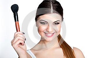 Beauty Girl make up artist with Makeup Brush. Bright Holiday Make-up for Brunette Woman with Brown Eyes. Beautiful Face. Makeover