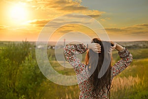 Beauty Girl Outdoors enjoying nature. Beautiful Model with long healthy blowing hair running on the Spring Field, Sun