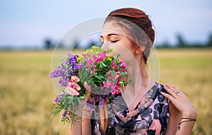 Beauty Girl Outdoors enjoying nature. Beautiful Teenage Model girl in dress on the Spring Field