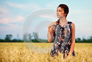 Beauty Girl Outdoors enjoying nature. Beautiful Teenage Model girl in dress on the Spring Field