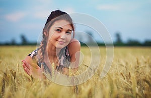 Beauty Girl Outdoors enjoying nature. Beautiful Teenage Model girl in dress on the Spring Field