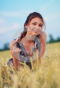 Beauty Girl Outdoors enjoying nature. Beautiful Teenage Model girl in dress on the Spring Field