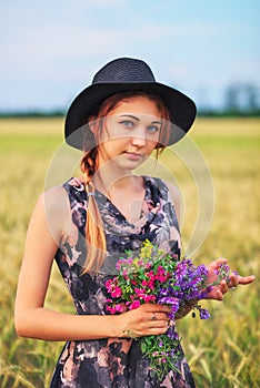 Beauty Girl Outdoors enjoying nature. Beautiful Teenage Model girl in dress on the Spring Field