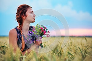Beauty Girl Outdoors enjoying nature. Beautiful Teenage Model girl in dress on the Spring Field