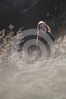 Beauty Girl Outdoors enjoying nature. Beautiful Teenage Model girl with long healthy blowing hair running on the Spring Field, Sun