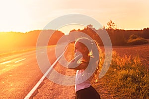 Beauty Girl Outdoors enjoying road trip at sunset. Beautiful Tee