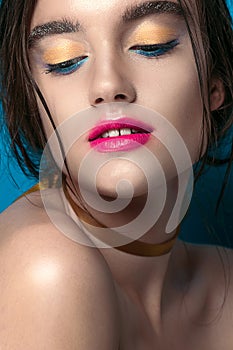 Beauty Girl Portrait with Vivid Makeup. Fashion Woman portrait close up on blue background. Bright Colors. Manicure Make up. Smoky