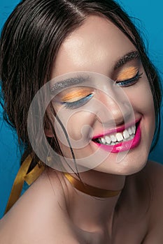 Beauty Girl Portrait with Vivid Makeup. Fashion Woman portrait close up on blue background. Bright Colors. Manicure Make up. Smoky