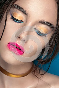 Beauty Girl Portrait with Vivid Makeup. Fashion Woman portrait close up on blue background. Bright Colors. Manicure Make up. Smoky