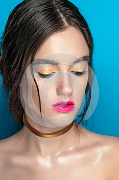 Beauty Girl Portrait with Vivid Makeup. Fashion Woman portrait close up on blue background. Bright Colors. Manicure Make up. Smoky