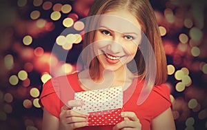 Beauty girl in red dress with gift box to Christmas or Valentine's Day