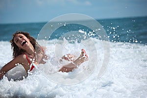 Beauty girl sits in sea surf