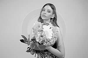 Beauty girl with spring peonies flowers. Beautiful sensual woman hold bouquet of peonies flowers, studio portrait on