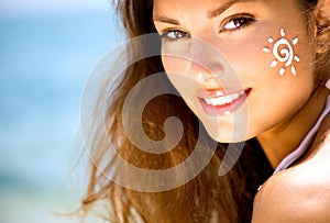 Beauty Girl with Sun Tan Cream on her Face photo