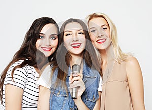 Beauty girls with a microphone singing and having fun together