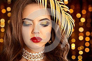 Beauty golden eye makeup. Fashion brunette portrait in gold. Sex