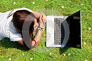 Beauty on a grass with computer.