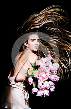Beauty hair salon. Sexy girl with spring tulips flowers bouquet. Spring hairstyle.