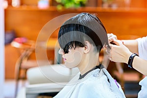 Beauty, hairstyle, treatment, hair care concept, young woman and hairdresser cutting hair at hairdressing salon. Hairdresser cutts