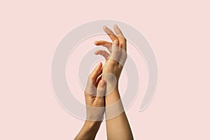 Beauty hands gently touching soft moisturized skin on pink background