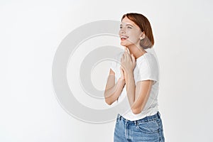 Beauty and happiness. Portrait of young woman looking left at logo, smiling and laughing carefree, standing in t-shirt