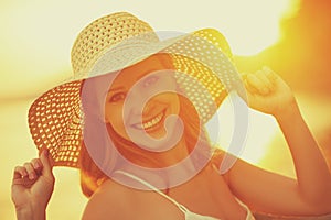 Beauty happy smiling woman in hat at sea at sunset on beach