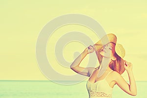 Beauty happy woman in hat enjoy sea at sunset on beach