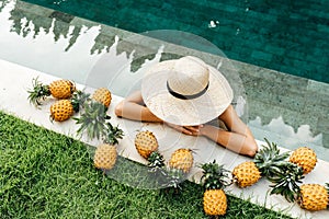 Beautiful Woman Relaxing In Swimming Pool With Pineapples. Healthy Lifestyle, Nutrition, Diet. Summer Vacation