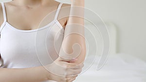 Beauty health young asian woman applying therapy cream or lotion or moisturizer touch elbow in the room