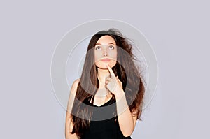 Beauty and health. Young woman looking at split ends. Damaged long hair