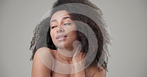 Beauty and Healthcare concept - Beautiful African American woman with curly afro hairstyle hair and clean, healthy skin