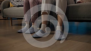 Portrait of young couple spending time together. Closeup shot of man and woman sitting on the sofa in pajamas and