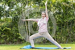 Beauty and healthy woman exercise and doing meditation of yoga on exercise mat in the outdoor park - fitness, sport, yoga